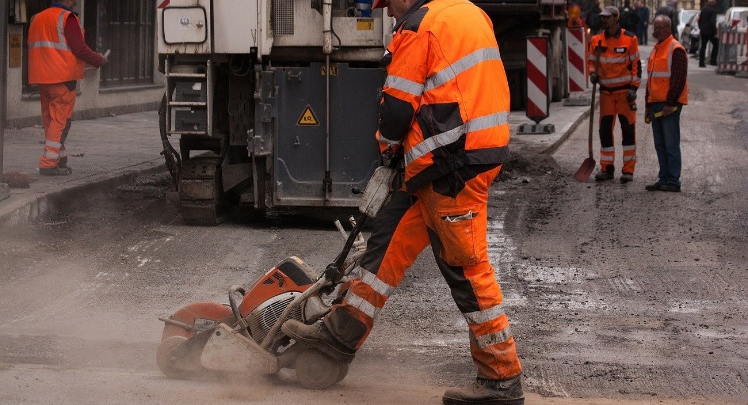 Een stratenmaker is aan het werk bij het repareren van een weg.